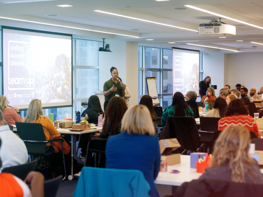 Team Up inaugural training. A participant is speaking in front of the room.