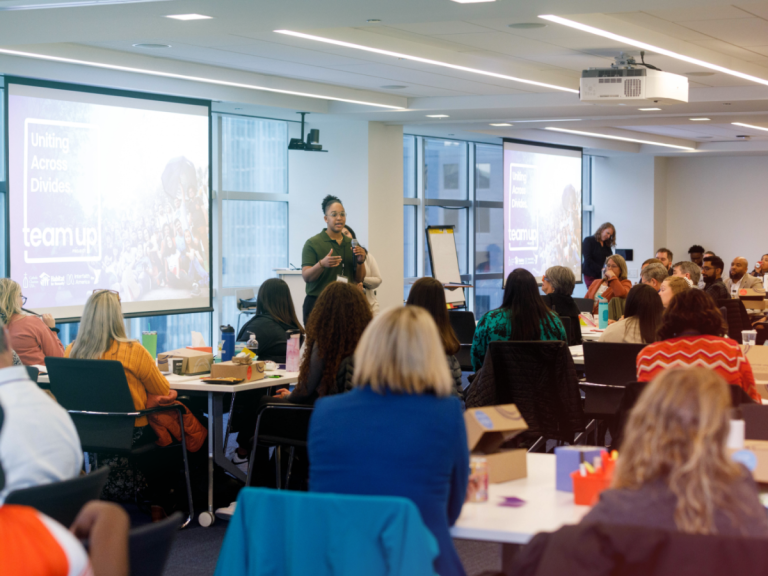 Team Up inaugural training. A participant is speaking in front of the room.