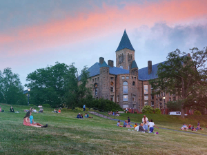 a castle and lawn with students at cornell
